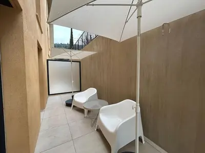 a room with two white chairs and an umbrella at Prestige View 103 By Avecoeur in Èze