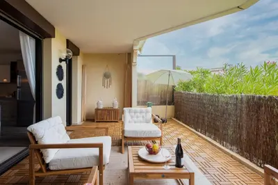 a patio with two chairs and a table and an umbrella at Happyfew Le Flora in Nice