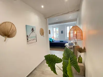 a living room with a couch and a potted plant at Spacieux Loft Cœur Vieux Nice in Nice