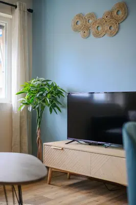 a living room with a flat screen tv on a dresser at Cosy Morning - L'Azur - Plage 100mètres in Cagnes-sur-Mer