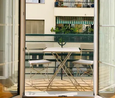 a table and two chairs outside a window at Chic & Spacious Getaway in Nice - 10min to Beach in Nice