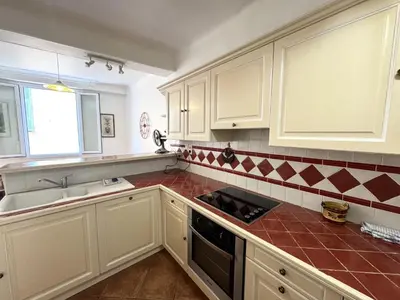 a kitchen with white cabinets and red tiles on the counters at ApartHotel Riviera - BARILLERIE 4 - 3 pieces - Old Town Promenade Anglais in Nice