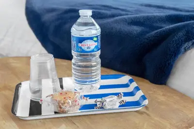 a bottle of water on a tray on a table at ApartHotel Riviera - BARILLERIE 4 - 3 pieces - Old Town Promenade Anglais in Nice