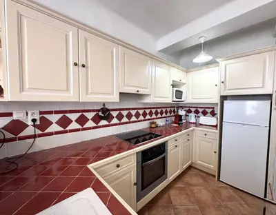 a kitchen with white cabinets and a red tile floor at ApartHotel Riviera - BARILLERIE 4 - 3 pieces - Old Town Promenade Anglais in Nice