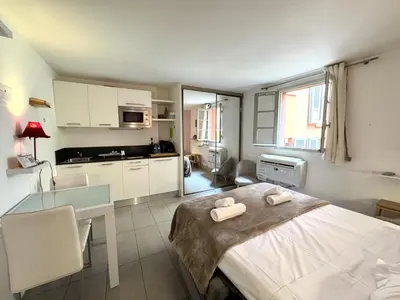 a room with a bed and a table and a kitchen at ApartHotel Riviera - MALONAT 3 - Grand Studio très calme -Old Town Promenade des Anglais in Nice