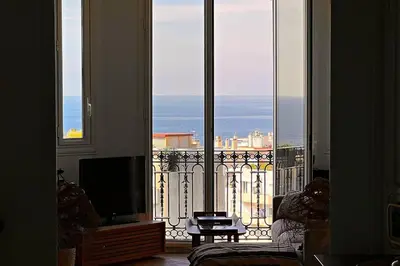 a living room with a large window with a view of the ocean at Le Palais Riviera in Nice