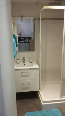 a white bathroom with a sink and a shower at Nice Charmant 2 pièces in Nice