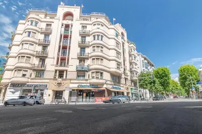 a large white building with cars parked in front of it at Nice Charmant 2 pièces in Nice