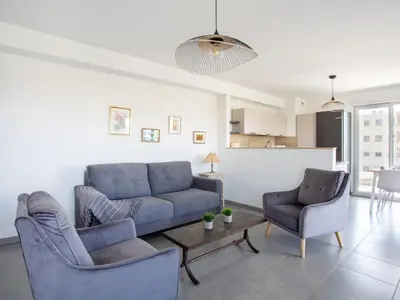 a living room with a blue couch and two chairs at Apartment Rive de Cagnes by Interhome in Cagnes-sur-Mer