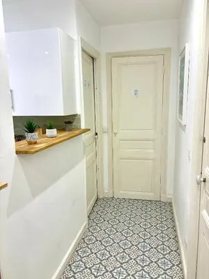 a kitchen with a white door and a tile floor at Les chambres de Cédric ICONIC TRAM GARE Nice Ville pour personnes CALMES in Nice