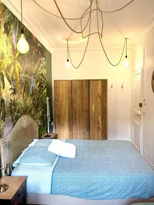 a bedroom with a blue bed with a mural on the wall at Les chambres de Cédric ICONIC TRAM GARE Nice Ville pour personnes CALMES in Nice