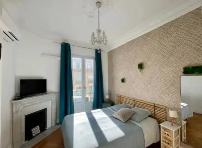 a bedroom with a bed with blue curtains and a fireplace at Les chambres de Cédric ICONIC TRAM GARE Nice Ville pour personnes CALMES in Nice