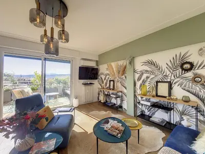 a living room with blue furniture and a large window at Nestor&Jeeves - SUN DECK TERRACE - Top Floor in Nice