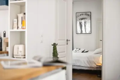 a white bedroom with a bed and a picture at La Cachette du Port! -Avec parking au Port de Nice in Nice