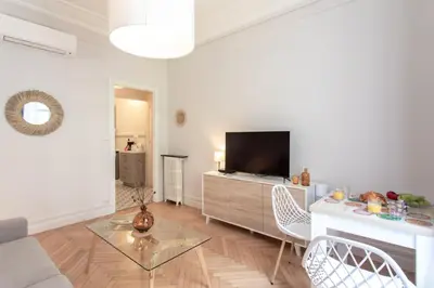 a living room with a television and a table and chairs at 26 Nice Parc Imperial studio in Nice