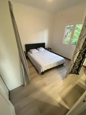 a bedroom with a bed and a wooden floor at Les studios des mandariniers in Cagnes-sur-Mer