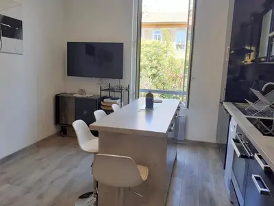 a kitchen with a table and chairs and a tv at 2 Pièces Neuf WIFI Quartier Borriglione in Nice