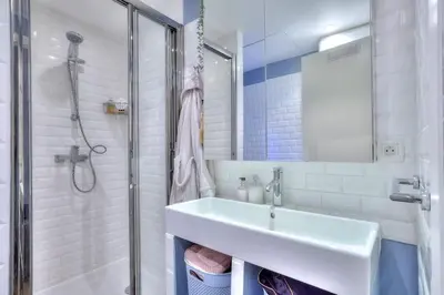a white bathroom with a sink and a shower at La Maison Hélène & Antoine Nice Le Port in Nice