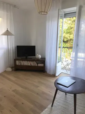a living room with a table and a chair and a television at Magnifique appartement Bas Gairaut aperçu mer in Nice