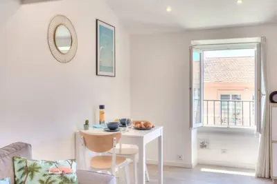 a white room with a table and a window at #2 Central Studio top floor AC & Balcony in Nice
