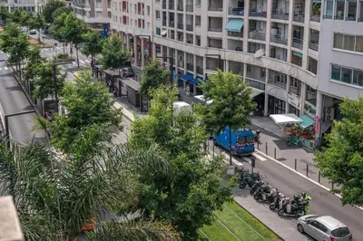 a city street with a blue truck driving down a street at Le balcon de la baie des Anges in Nice