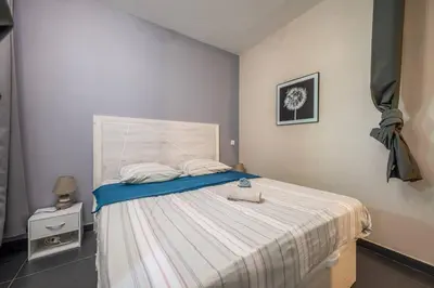 a bedroom with a bed with a striped bedspread at Le balcon de la baie des Anges in Nice