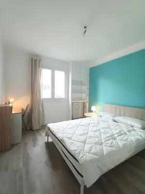 a bedroom with a large bed with a blue wall at F4 avec vue mer / Flat with sea view 3 bedrooms in Nice