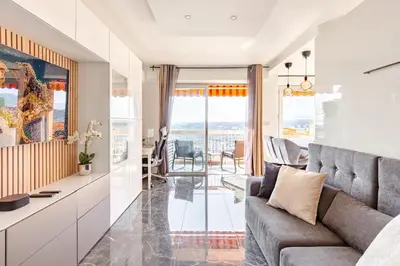 a living room with a couch and a table at Vue mer et montagne panoramique in Nice