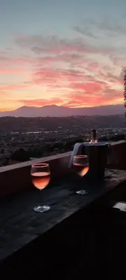 two wine glasses sitting on a ledge with a sunset at Vue mer et montagne panoramique in Nice
