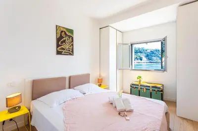 a bedroom with a bed with two towels on it at LA RESERVE AP4369 By Riviera Holiday Homes in Villefranche-sur-Mer