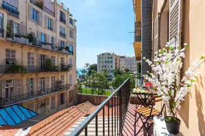 a balcony with a table and chairs and buildings at LE ST FRANCOIS AP4368 By Riviera Holiday Homes in Nice