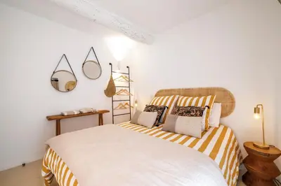 a bedroom with a large bed with striped sheets at Nice Renting - NEUVE - Luxury Triplex Old Town Massena Garibaldi - 4 BedRoom - AC in Nice