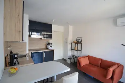 a kitchen and living room with a couch and a table at VILLA SMOLETT - Appartement Cosy au cœur du quartier du port in Nice