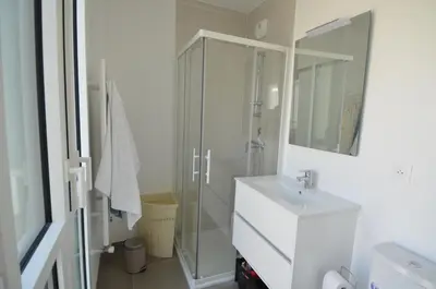 a white bathroom with a shower and a sink at VILLA SMOLETT - Appartement Cosy au cœur du quartier du port in Nice
