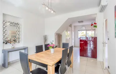 a dining room with a wooden table and chairs at Nice Home In Saint-Laurent-Du-Var in Saint-Laurent-du-Var