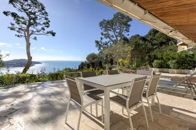 a table and chairs on a patio with a view of the ocean at Giant Terrace on a stunning View in Villefranche-sur-Mer