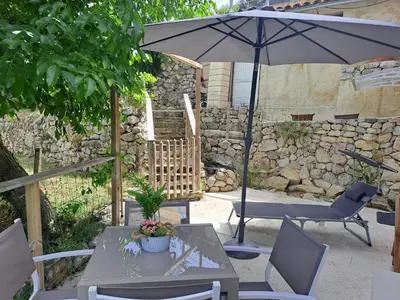 a patio with a table and an umbrella and chairs at Domaine luna estella in Tourrette-Levens