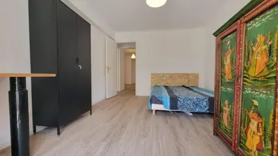 a room with a bed and a large painting on the wall at appartement neuf de 3 pieces avec climatisation in Nice