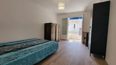 a bedroom with a bed and a large window at appartement neuf de 3 pieces avec climatisation in Nice