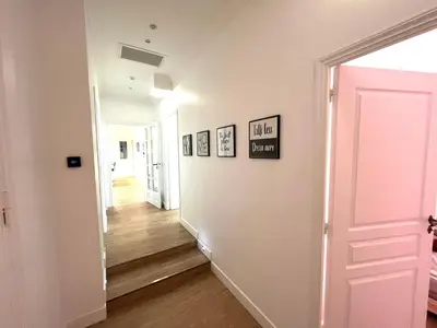 a hallway with a white wall with pictures on it at Large Haussmanian appartment in the heart of Nice in Nice