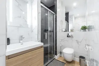 a white bathroom with a sink and a shower at Large Haussmanian appartment in the heart of Nice in Nice