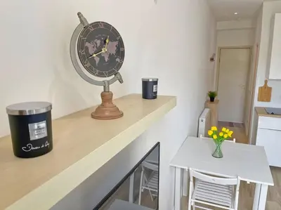 a clock sitting on top of a counter next to a table at Studio au coeur de Nice in Nice