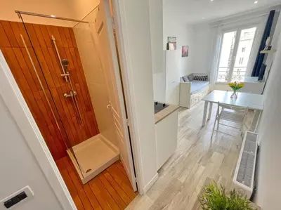 a hallway with a wooden door and a table in a room at Studio au coeur de Nice in Nice
