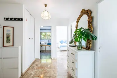 a white room with a mirror and a dresser at Résidence méditerranée - Beachfront - Sun and Seaview - Pool - Private Parking in Cagnes-sur-Mer