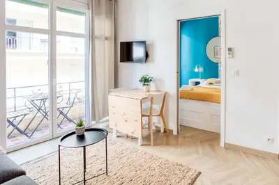 a bedroom with a bed and a table and a mirror at #10 2Pièces Fricéro 3min to the beach/Balcon & AC in Nice