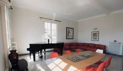 a living room with a table and a piano at Villa prestigieuse avec piscine privée au cœur de Nice in Nice
