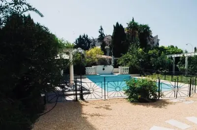 a fence around a swimming pool in a yard at Villa prestigieuse avec piscine privée au cœur de Nice in Nice