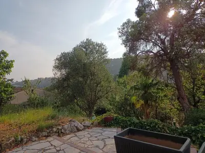 a garden with a bench and trees in the background at Joli 3p - Bas de villa in Saint-Andre-de-la-Roche