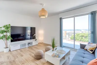 a living room with a blue couch and a large window at L43 Suite Maurice sea view 6Pax/Terrace,Parking,AC in Saint-Laurent-du-Var