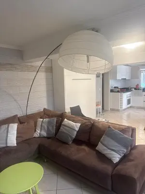 a living room with a brown couch and a green table at Studio proche mer avec piscine Cros de cagnes in Cagnes-sur-Mer